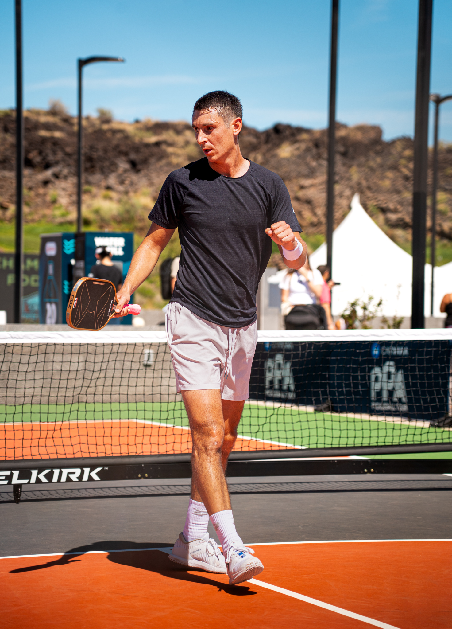 Ivan Jakovljevic walking forward on court between points.